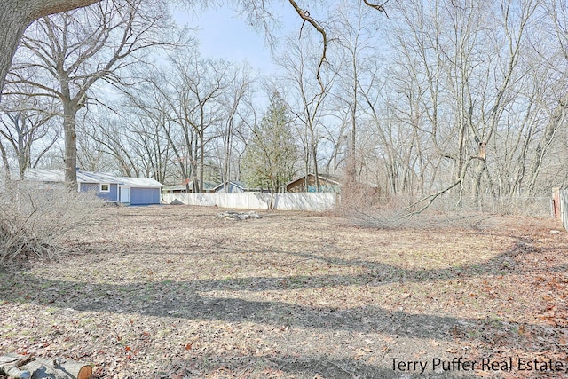 view of yard featuring an outdoor structure and fence