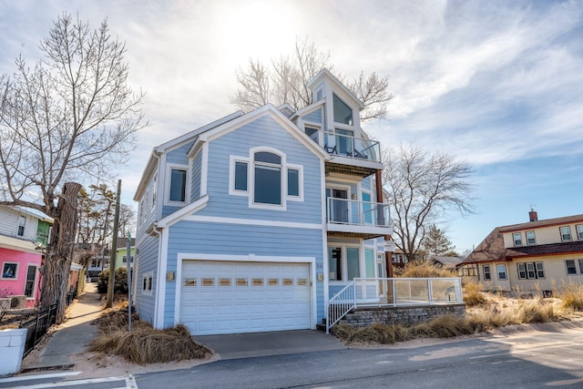 view of front of house with a balcony, an attached garage, and driveway