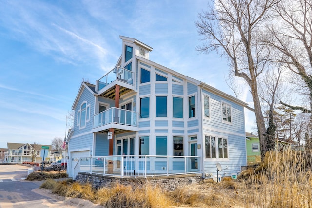 rear view of property with a balcony and a garage