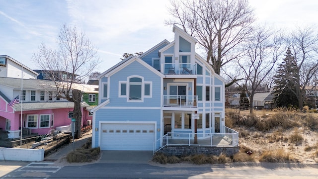 view of front of house featuring a garage, a balcony, a porch, and concrete driveway