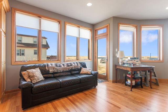 living area featuring recessed lighting, baseboards, and light wood finished floors