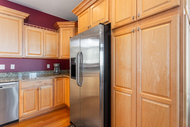 kitchen featuring light brown cabinetry, light wood finished floors, appliances with stainless steel finishes, and light stone counters