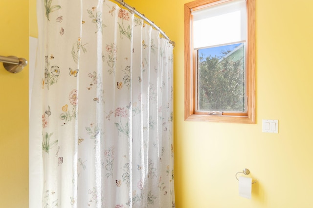 full bath with a shower with curtain and a healthy amount of sunlight