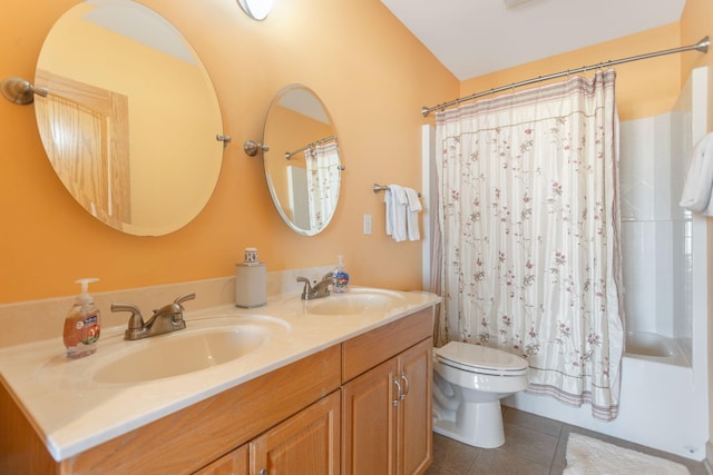 bathroom with tile patterned floors, double vanity, toilet, and a sink