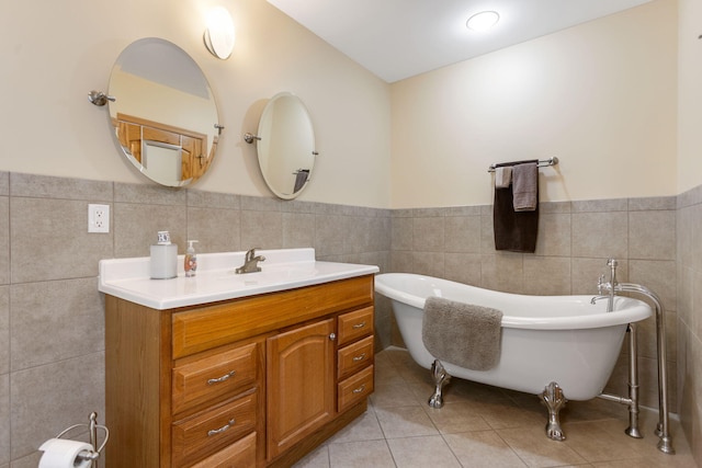 full bathroom featuring tile patterned flooring, a soaking tub, wainscoting, and vanity