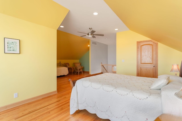 bedroom featuring visible vents, recessed lighting, light wood finished floors, baseboards, and vaulted ceiling