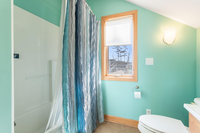 full bath with tile patterned flooring, shower / bath combo with shower curtain, toilet, and baseboards