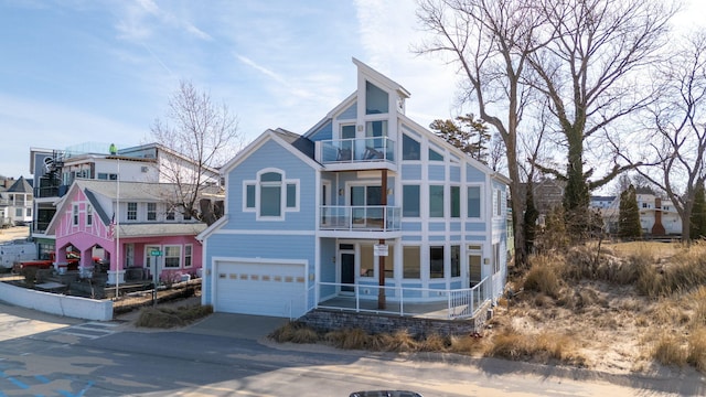 view of front of property with a balcony, concrete driveway, and an attached garage