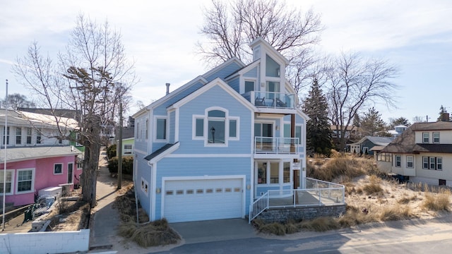 view of front of home featuring concrete driveway, a balcony, and a garage