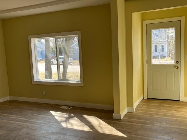 interior space featuring visible vents, baseboards, and wood finished floors