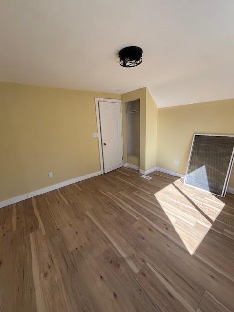 unfurnished room with baseboards and wood finished floors