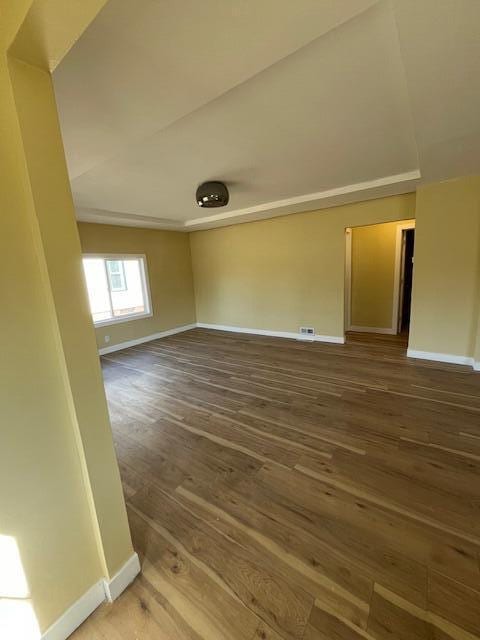 unfurnished room featuring baseboards and wood finished floors