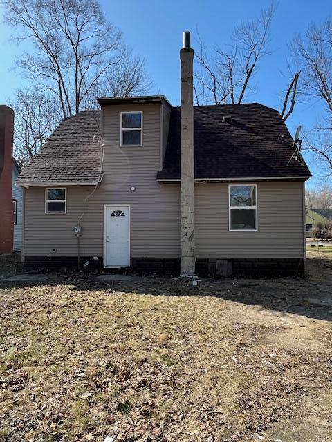 back of property featuring roof with shingles