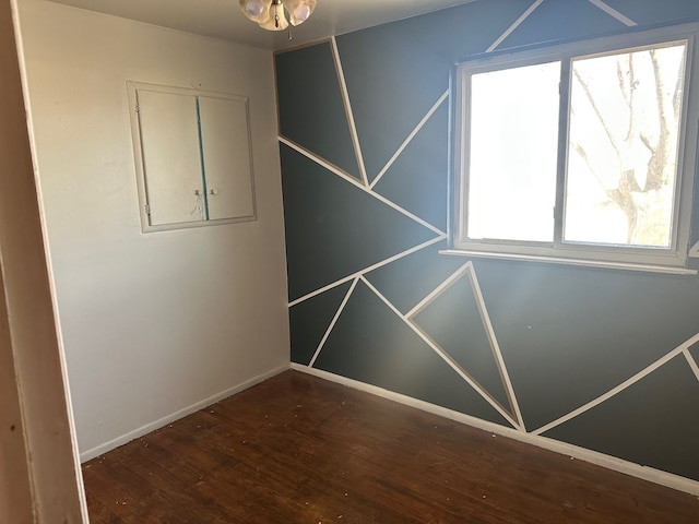 spare room featuring hardwood / wood-style flooring and baseboards