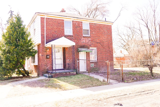 view of front facade featuring brick siding, a chimney, and fence