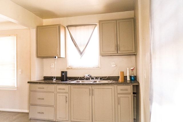 kitchen with dark countertops, baseboards, and a sink