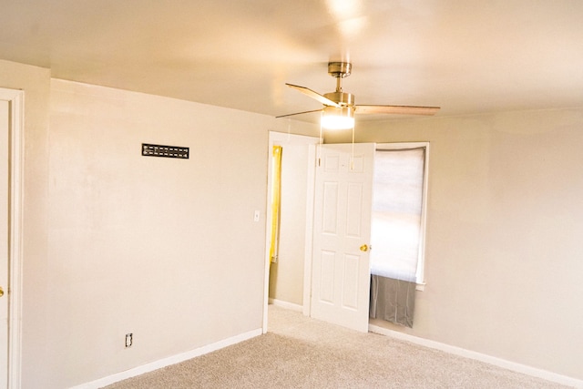 unfurnished room with a ceiling fan, baseboards, and carpet floors