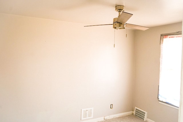 empty room with a wealth of natural light, visible vents, and light colored carpet