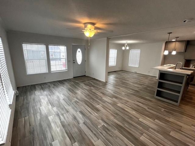 foyer entrance with dark wood-type flooring and ceiling fan with notable chandelier