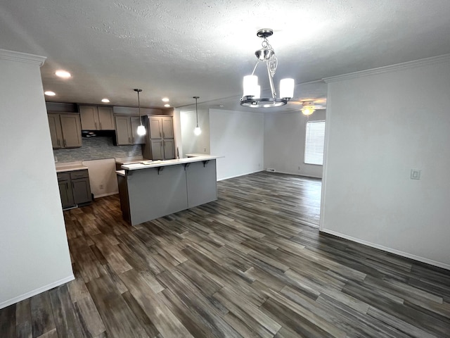 kitchen with a kitchen breakfast bar, open floor plan, dark wood-style floors, an inviting chandelier, and decorative backsplash