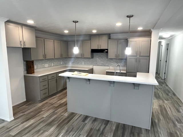 kitchen featuring crown molding, dark wood-style floors, a kitchen island, and gray cabinetry