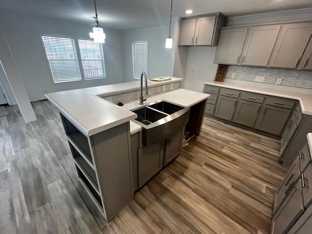 kitchen featuring crown molding, light countertops, gray cabinets, and a sink