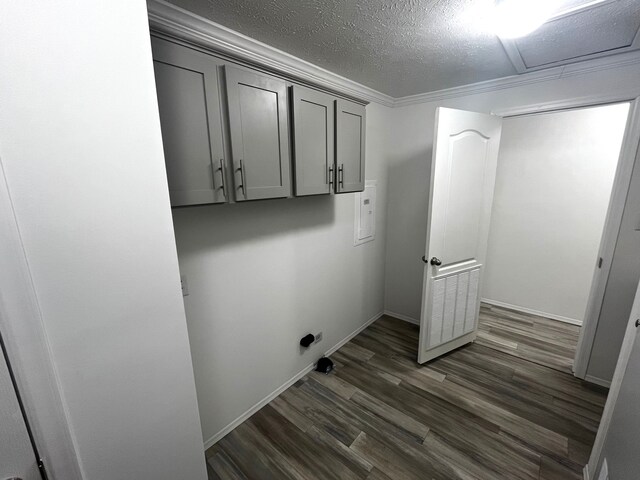 washroom with laundry area, attic access, dark wood-type flooring, a textured ceiling, and crown molding