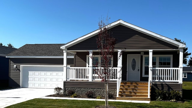 view of front of house with driveway, a porch, an attached garage, and a shingled roof