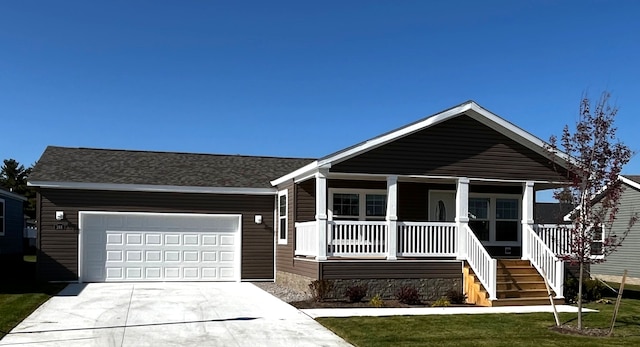 view of front of property with a porch, concrete driveway, a front yard, an attached garage, and stairs