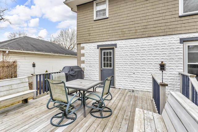 wooden deck with area for grilling and outdoor dining space