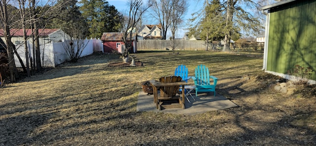 view of yard featuring an outbuilding, a fenced backyard, and a patio area