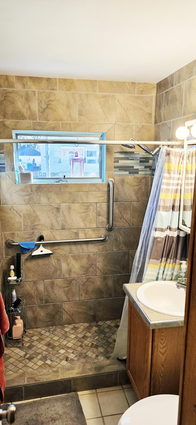 bathroom featuring vanity, tile patterned flooring, and a tile shower