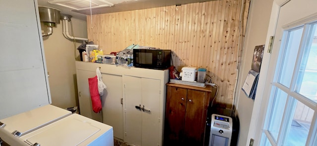 laundry room with heating unit, wooden walls, laundry area, and separate washer and dryer