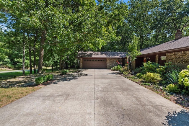 view of front facade featuring brick siding, concrete driveway, an attached garage, and a shingled roof