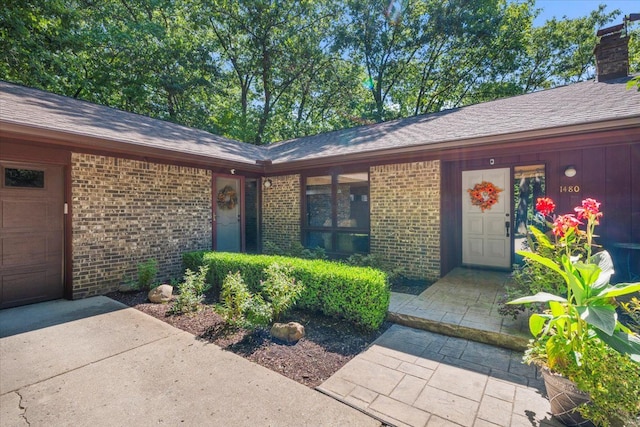 entrance to property featuring brick siding and a chimney