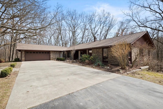 view of front of home with driveway, a chimney, and an attached garage