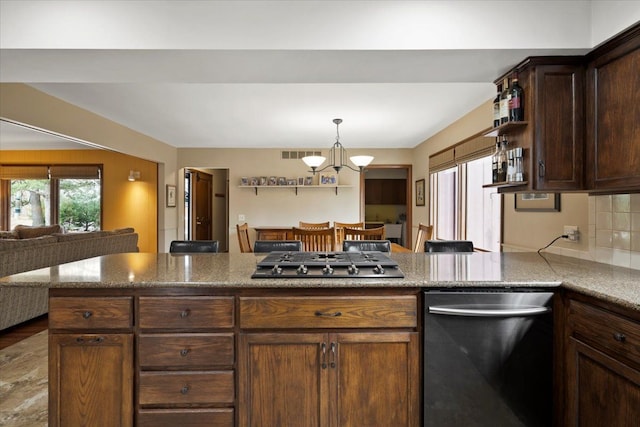 kitchen featuring light stone counters, stainless steel appliances, open floor plan, and hanging light fixtures