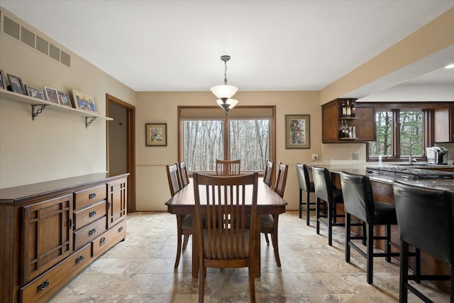 dining area featuring visible vents and stone finish flooring