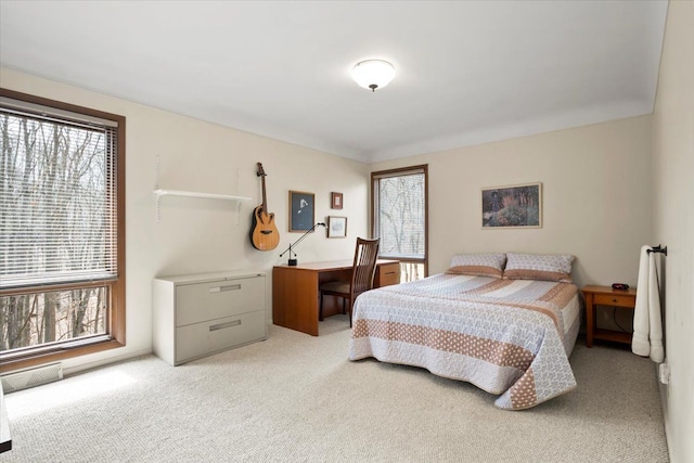 bedroom with multiple windows and light colored carpet