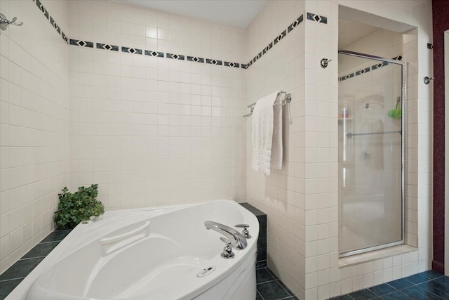 full bathroom featuring tile patterned floors, tile walls, a bath, and a shower stall