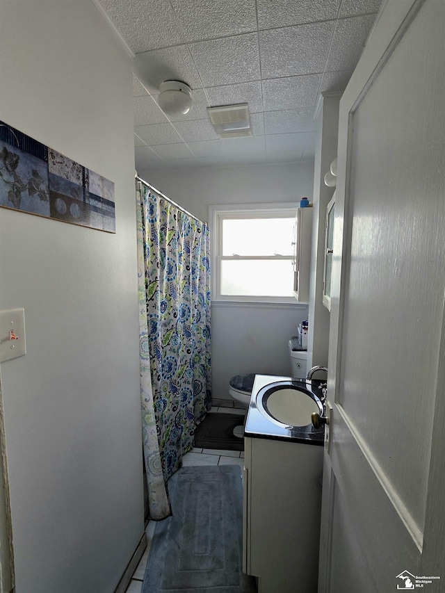 bathroom featuring vanity, toilet, a shower with curtain, and a drop ceiling