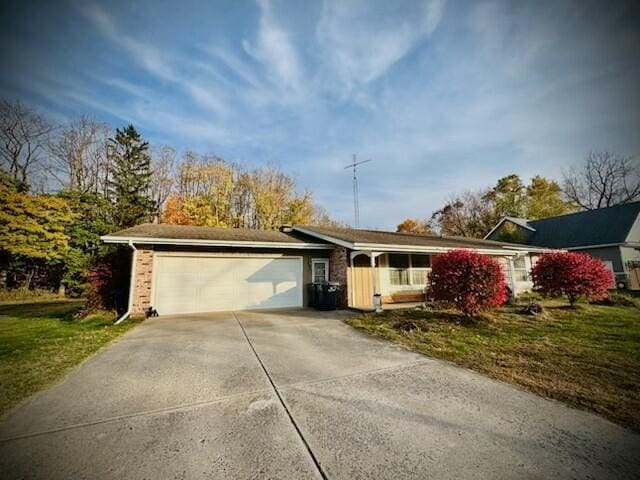 single story home featuring a front lawn, concrete driveway, and an attached garage