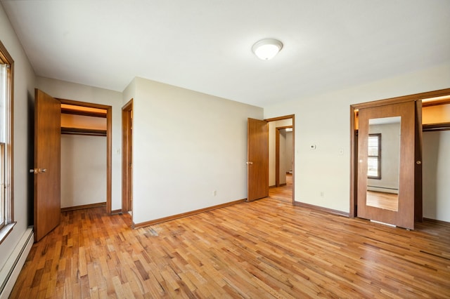 unfurnished bedroom with light wood-style flooring, baseboards, and baseboard heating