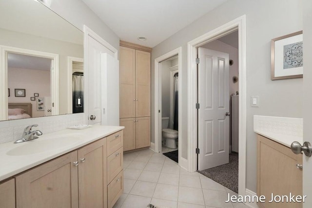 ensuite bathroom featuring vanity, toilet, tile patterned flooring, and connected bathroom