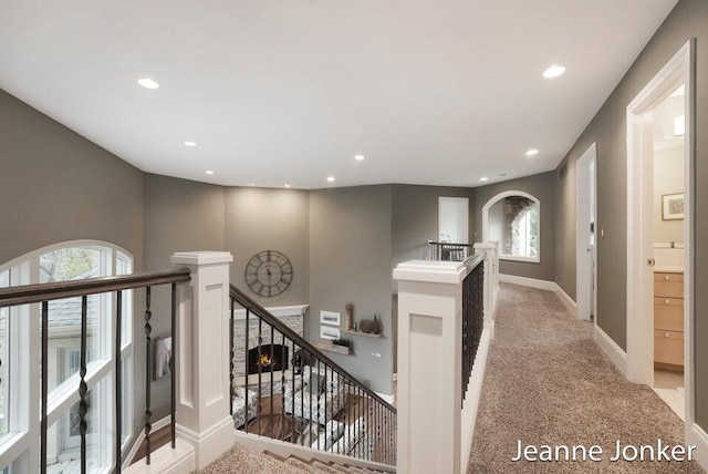 hall featuring recessed lighting, baseboards, an upstairs landing, and carpet