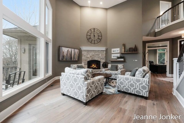 living area featuring a high ceiling, wood finished floors, and baseboards