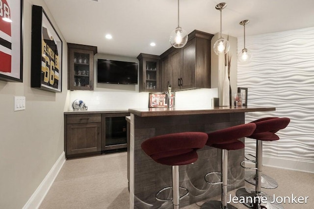 bar featuring recessed lighting, baseboards, a bar, and hanging light fixtures