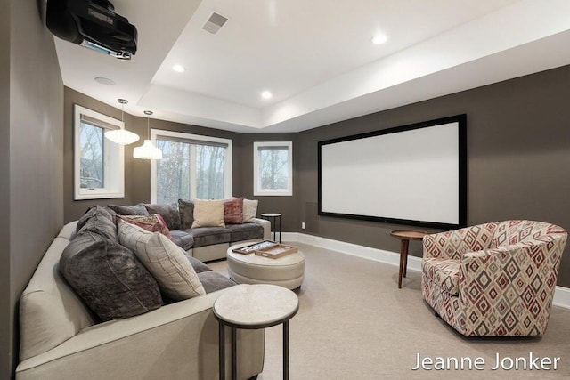 home theater room with visible vents, carpet, baseboards, a tray ceiling, and recessed lighting