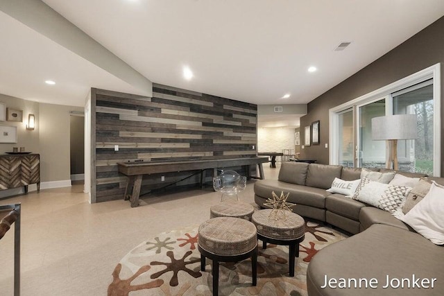 living area featuring recessed lighting, visible vents, baseboards, and an accent wall