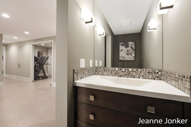 bathroom with decorative backsplash, recessed lighting, vanity, and baseboards